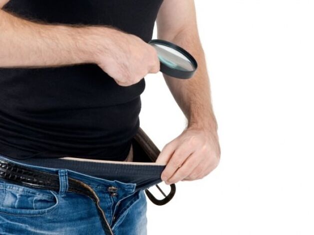 一个男人低头看自己的裤子，想增大自己的阴茎